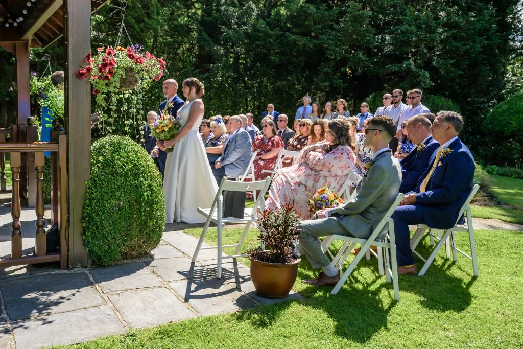 Lucy and Andy getting married outside in the garden gazebo at Briery Wood