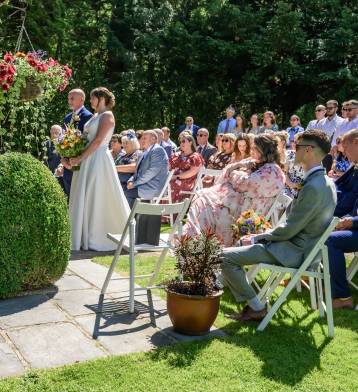 Lucy and Andy getting married outside in the garden gazebo at Briery Wood